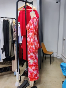 Detail of elegant long-sleeve floral maxi dress with ruched texture and vibrant patterns