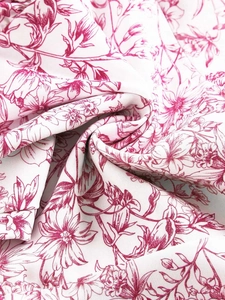 Detailed macro view of the vintage floral print fabric with pink flowers on white base