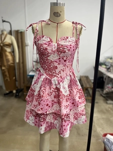 Detailansicht eines rosa Blumenkleides mit Spaghettiträgern und Schleifenverzierung