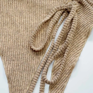 Gros plan sur le tricot côtelé kaki avec trois liens latéraux parallèles et textures