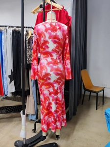 Detail of slim fit maxi dress featuring vibrant red and pink abstract floral prints