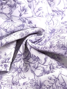 Close-up of floral print fabric with delicate lavender flowers and soft pleated texture