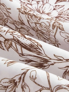 Close-up of floral print fabric detail on a white summer dress with botanical patterns