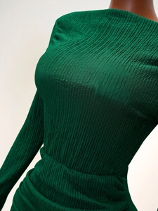 Détail de robe en maille vert foncé avec taille haute et texture plissée élégante