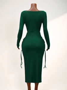 Détail de la robe en maille vert forêt montrant le tissu texturé et les cordons latéraux