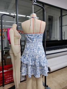 Detailed view of floral halter dress with multi-layer ruffled hem and back zipper closure