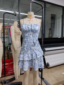 Detail of blue and white floral summer mini dress with ruffled tiered hem and halter neck