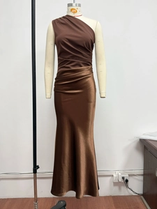 Detail of dark brown one-shoulder dress with pleated bodice and satin skirt texture