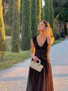 Detail of elegant V-neck lace bodice and flowing chiffon skirt on a black evening gown