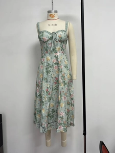 Detail eines hellgrünen floralen Midikleids mit Rüschenausschnitt und Bindebogendesign