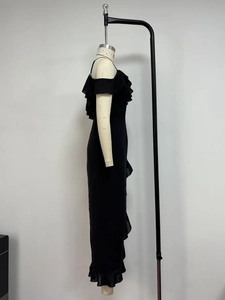 Detail view of black chiffon off-shoulder dress featuring layered ruffles and high slit