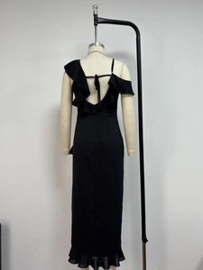 Detail of black chiffon backless dress with ruffled hem and crisscross lace-up design