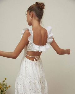 Dettaglio dell'abito in cotone bianco con ricami floreali e chiusura con lacci sul retro