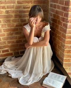Detail of elegant V-neck lace trim and chiffon fabric on a vintage cream party dress