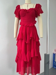 Détail du volant rouge multicouche et de la texture du tissu en mousseline sur la robe maxi