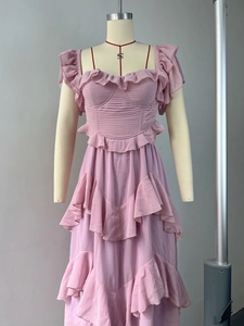 Détail de l'encolure carrée et du tissu mousseline plissé sur robe rose clair à volants