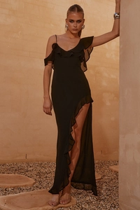 Detail view of black chiffon dress with ruffled hem and sexy high slit in outdoor lighting