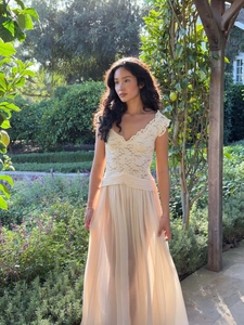 Detail of the V-neck lace bodice and pleated waist on an elegant beige chiffon maxi dress