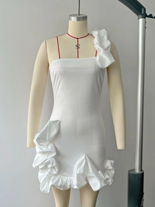 Détail d'une robe blanche à épaule unique avec volants et tissu texturé ajusté