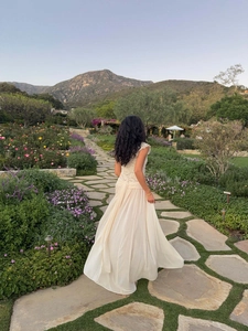 Elegant white lace and chiffon evening dress with a large flowing skirt shown from behind
