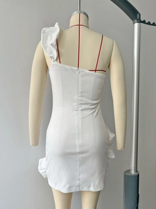 Détail de la robe blanche à une épaule montrant la bretelle volantée et le zip discret