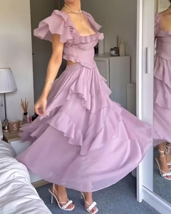 Détail d'une robe lavande à volants étagés avec découpes latérales et jupe plissée fluide