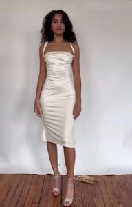 Détail de la robe midi en satin crème avec col bénitier et coupe ajustée élégante