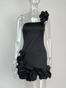 Vue détaillée d'une robe noire à une épaule avec fleur 3D et ourlet à volants froncés