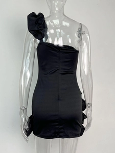 Détail de la robe satinée noire à une épaule avec fermeture éclair et volants