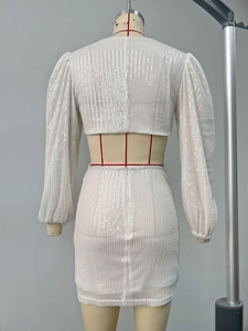 Detail of white sequin dress showing back open cut-out and shimmering beadwork fabric