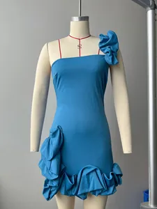 Détail de la décoration florale 3D et de l'ourlet à volants sur la robe bleu vif