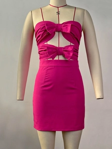 Detailweergave van fuchsia mini-jurk met gestapelde strikken en taille-uitsparingen
