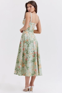 Detail eines mintgrünen Midikleides mit Blumenmuster, Spaghettiträgern und Pfirsichblüten