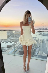 Détail d'une mini robe blanche bustier avec de grandes fleurs 3D à volants et coupe ajustée
