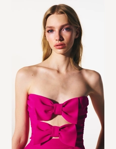 Gedetailleerd vooraanzicht van roze strapless top met twee grote 3D-strikken en uitsnijding