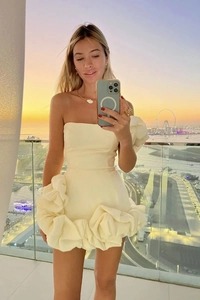 Détail de la robe courte ivoire à épaules dénudées avec ourlet floral 3D et manche bouffante