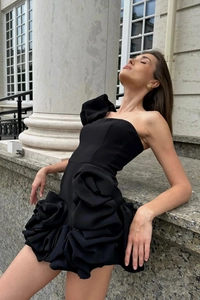 Détail d'une robe de cocktail noire élégante avec des volants floraux en 3D