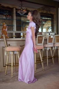Détail d'une robe longue en soie lilas avec décolleté en V et motifs floraux élégants