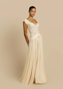Detail of elegant V-neck lace bodice and pleated chiffon skirt on a long beige evening dress