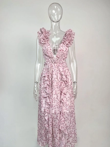 Détail d'une robe longue fleurie rose avec décolleté en V, volants et découpes à la taille