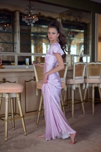Détail d'une robe longue fleurie violet clair avec manches à volants et fini satin