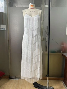 Détail des couches de franges blanches sur cette robe longue sexy à dos nu et col en V