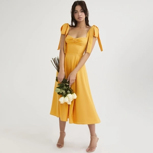 Elegant bright yellow French vacation dress with bow straps and sweetheart neckline