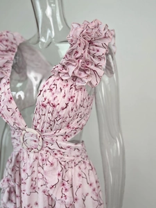 Détail d'une robe longue fleurie avec épaules à volants et découpe à la taille latérale