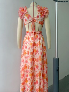 Détail d'une robe maxi fleurie dos nu avec bretelles nouées et volants aux épaules