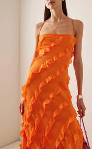 Détail de la robe orange vif avec volants multicouches et bretelles fines