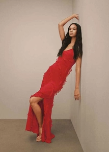 Detail view of red chiffon evening dress featuring tiered ruffles and high leg slit