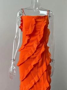 Détail d'une robe d'été orange vif avec des volants diagonaux multicouches et une fente