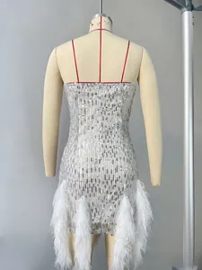 Détail d'une robe à paillettes argentées avec bordure en plumes blanches et fines bretelles