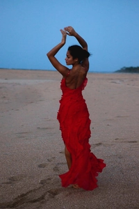 Detail view of tiered ruffles on a vibrant red backless chiffon maxi dress at the beach